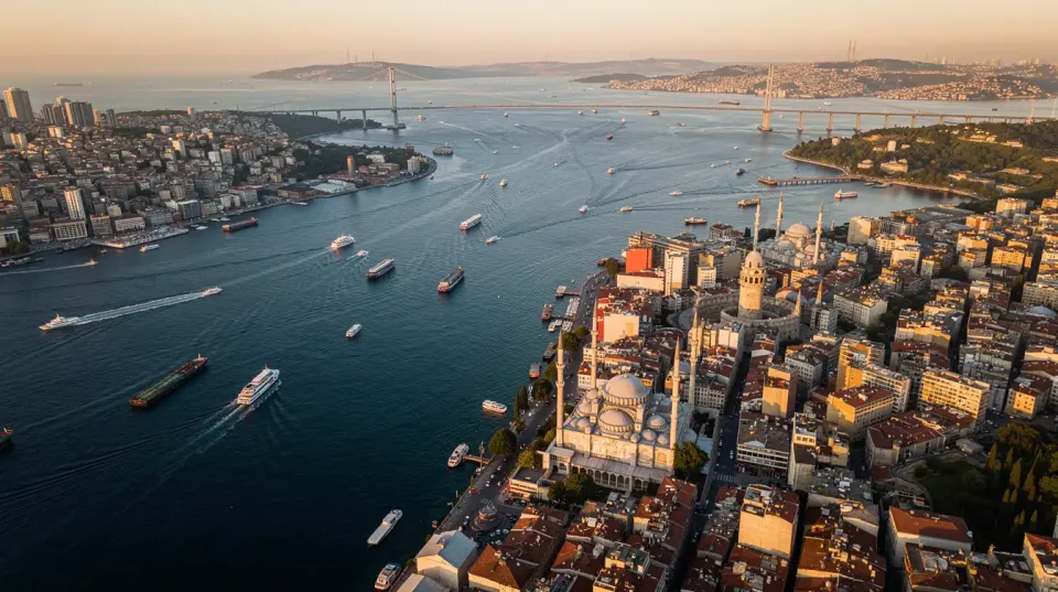 An aerial view of Istanbul captures the scenic Bosphorus strait, lined with historic buildings and minarets, while boats glide across the water. This vibrant cityscape showcases Turkey's rich cultural heritage, making it a popular destination for dental holidays and affordable dental treatments.